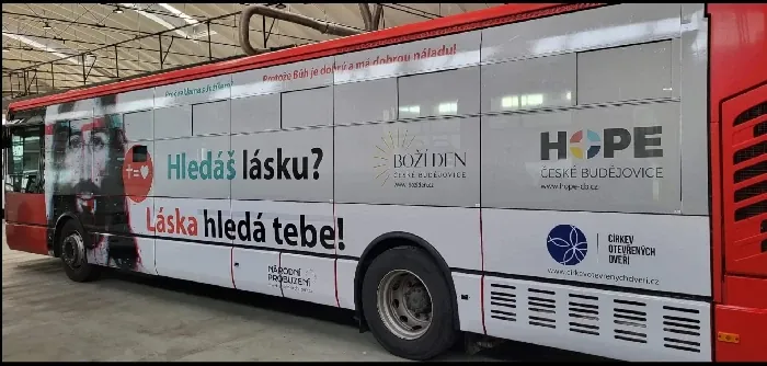 Autobus polepený pozvánkou v garáži dopravního podniku