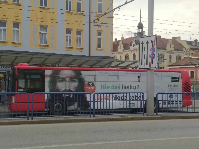 Autobus s nápisem Hledáš lásku? Láska hledá tebe! na zastávce